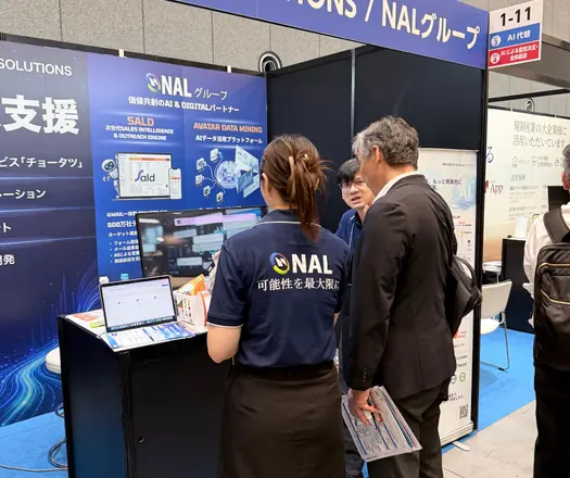 日本の展示会ブースで来場者に説明するメンバー